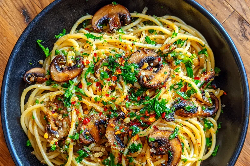 A vibrant display of fresh ingredients for Quick Mushroom Garlic Pasta, including pasta, mushrooms, garlic, and herbs.